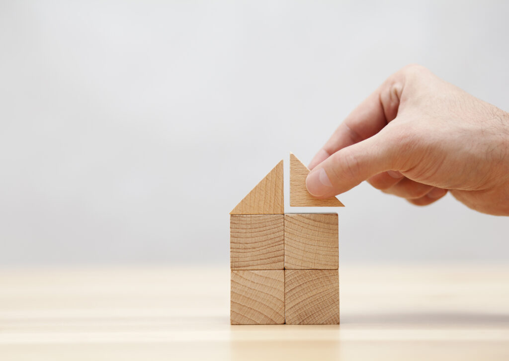 Hand building house with wooden blocks - 住宅AIコンシェルジュ